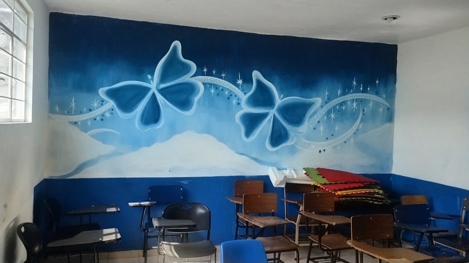 Aula creativa con mural de mariposas